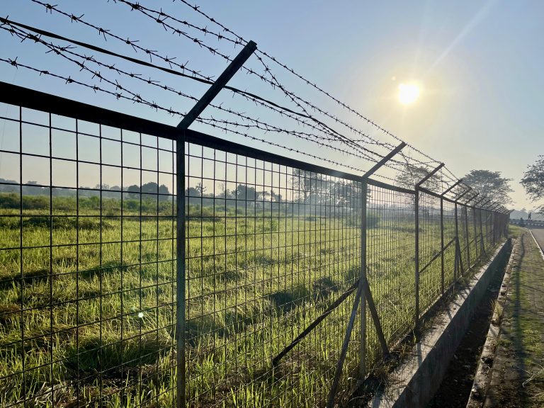 barbed-wire-fence-with-grass-clear-blue-sky-morning