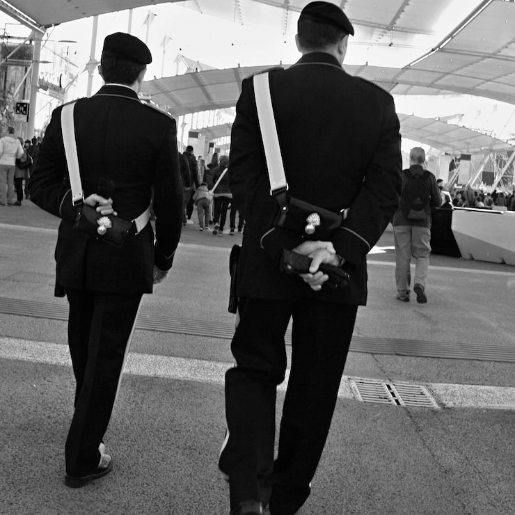 rear-view-carabinieri-men-walking-walkway_1612775-145